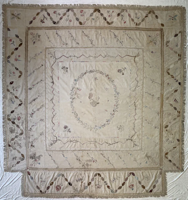 Discoloured counterpane before conservation treatment