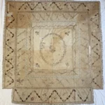 Discoloured counterpane before conservation treatment