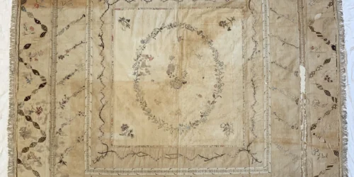 Discoloured counterpane before conservation treatment