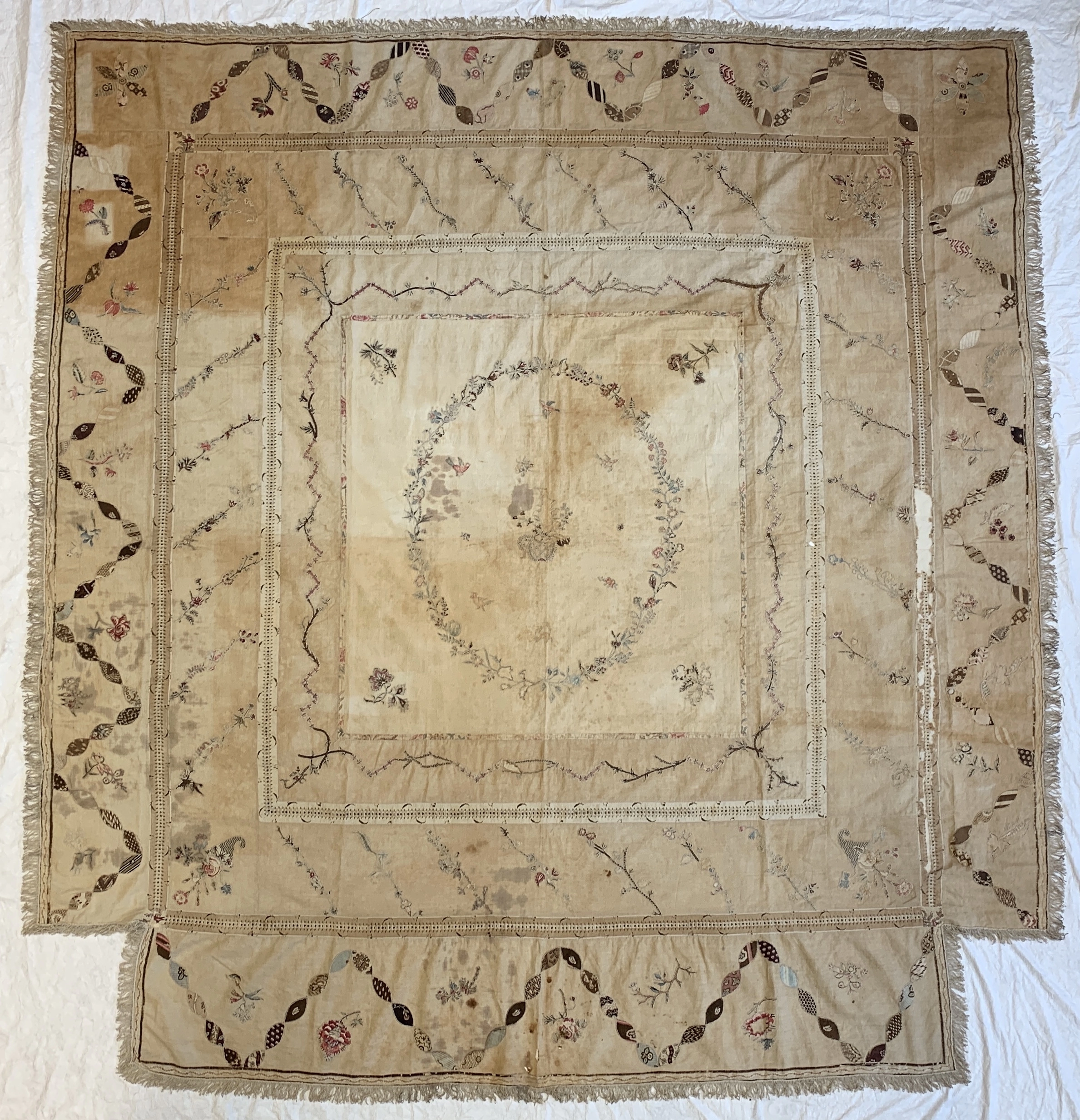 Discoloured counterpane before conservation treatment