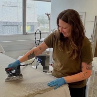 Conservator ironing a textile 