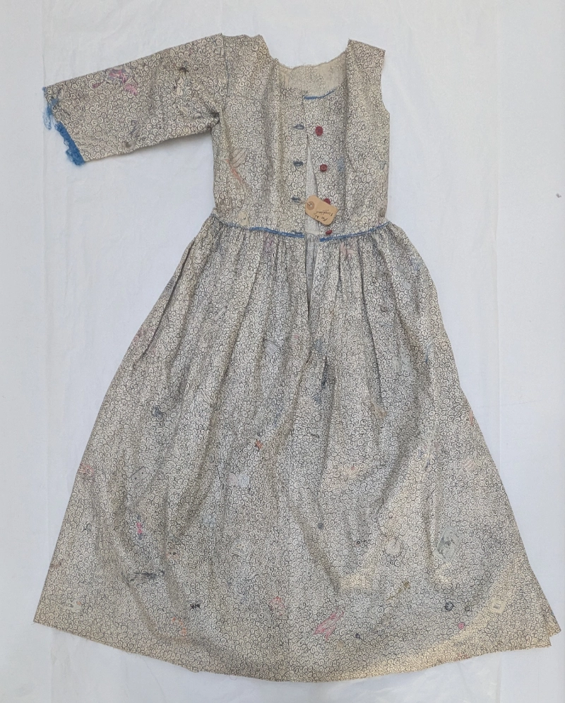 Hand painted dress before conservation with missing sleeve and frayed and broken blue trim
